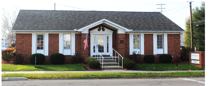 a large brick building with grass in front of a house